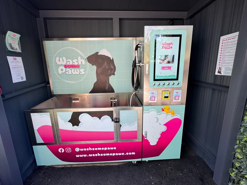 Wide view of the stainless steel tub and branded cabinet of the wash station